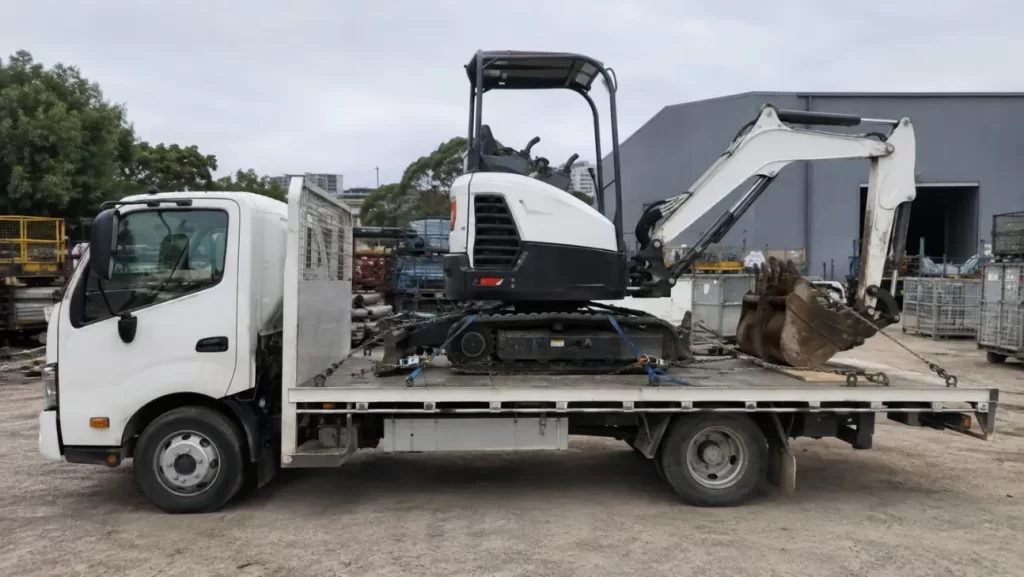 Excavator secured on tilt tray