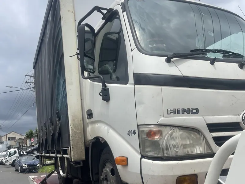 Truck towing Sydney: Hino light truck secured on a tilt tray tow truck for transport