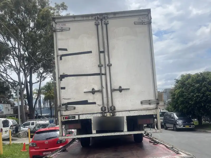 Pantech truck carried on a tilt tray tow truck