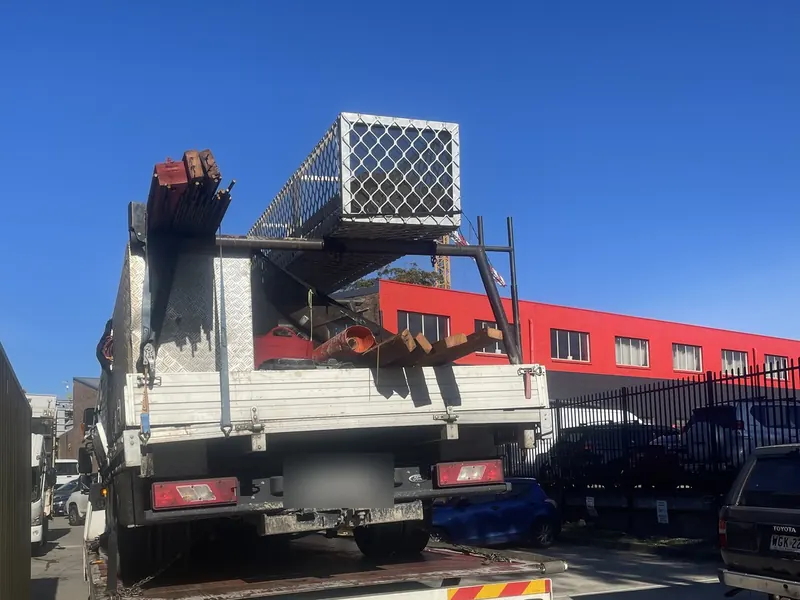 Tradie truck with a roof rack secured on a tilt tray tow truck
